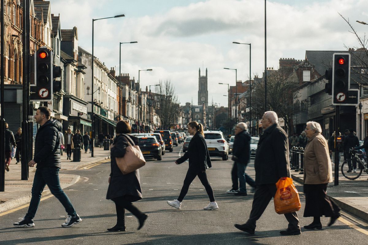 Pedestrians crossing a bustling Aigburth Road street in Liverpool