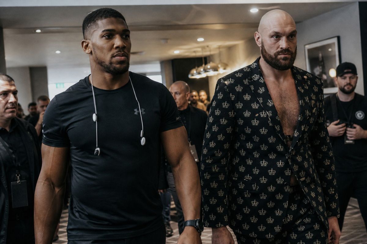 Anthony Joshua and Tyson Fury walking into a press conference room
