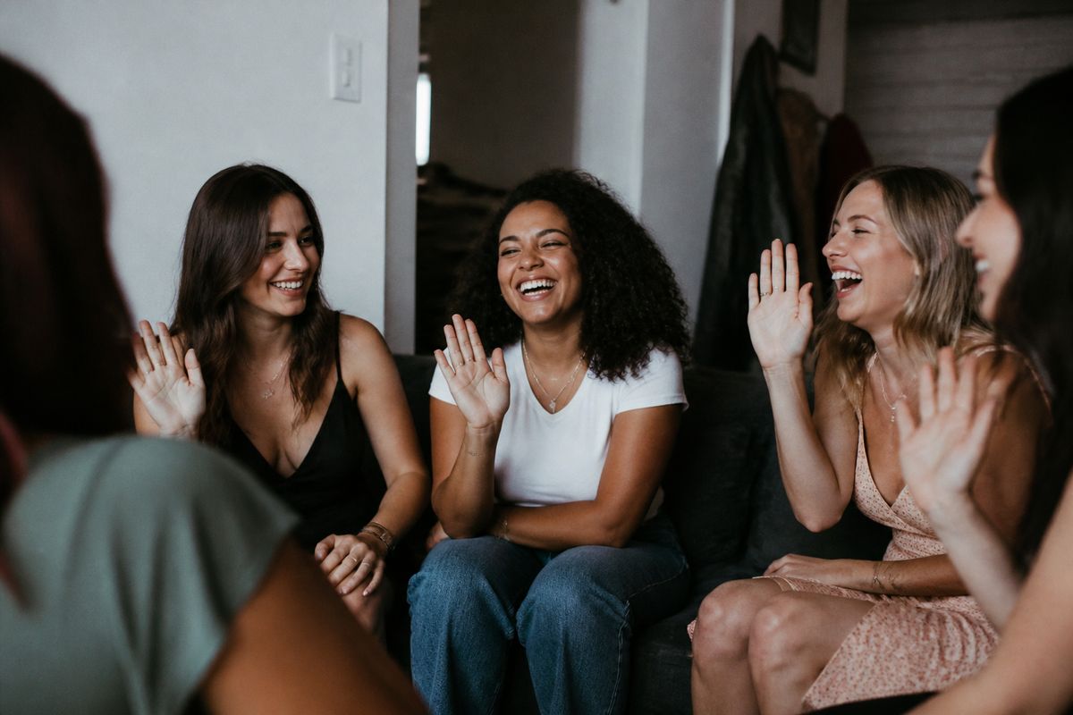 A group of women laughing while playing Never Have I Ever.