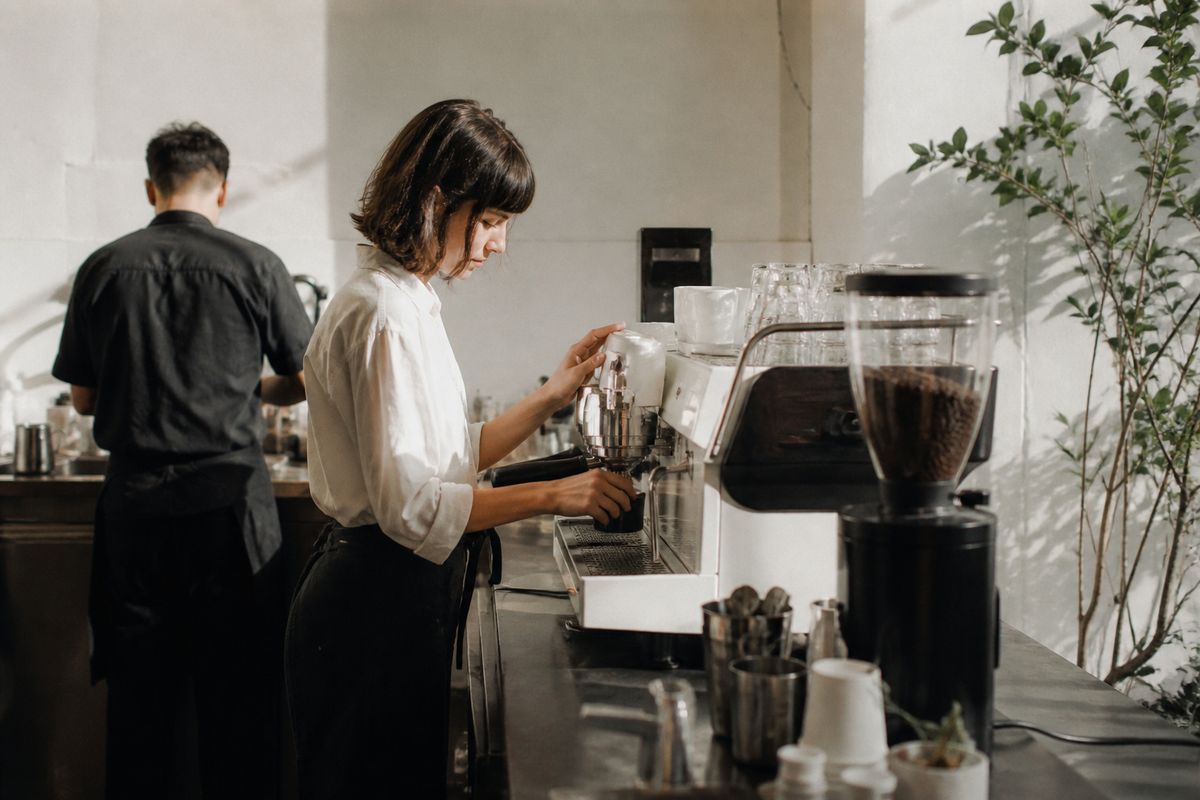 Baristas crafting espresso in a minimalist coffee shop interior