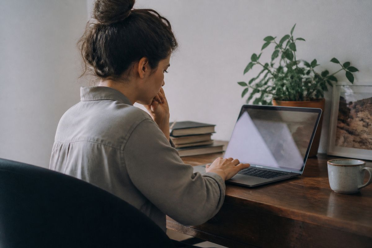 A person checking their driver's license status on a laptop.