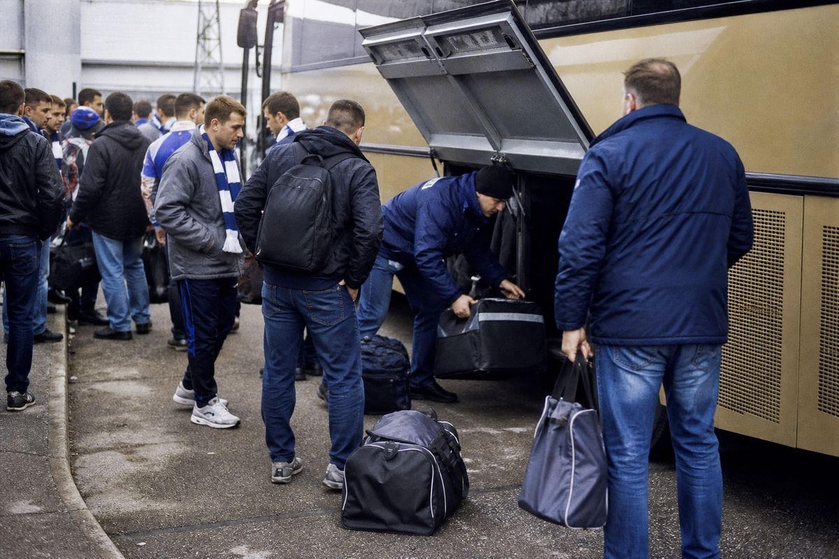Fans loading luggage onto a shared coach for an away match