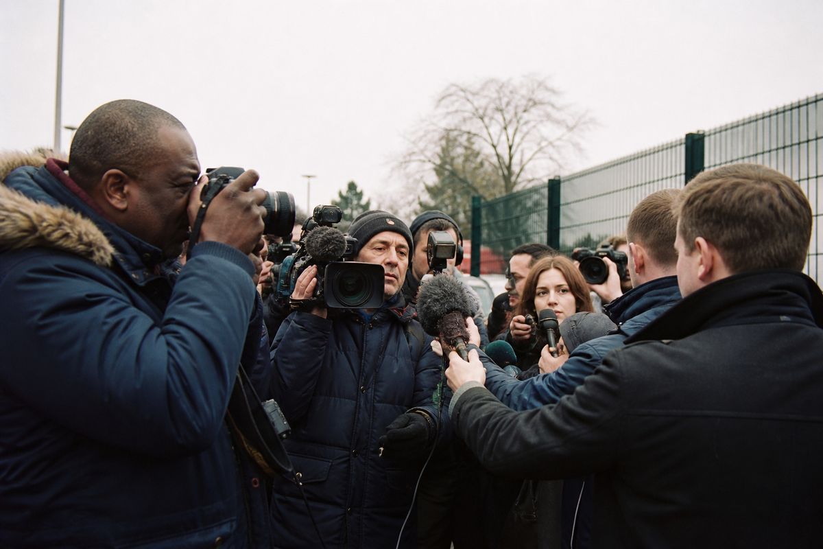 Reporters crowding outside a football club's training ground.