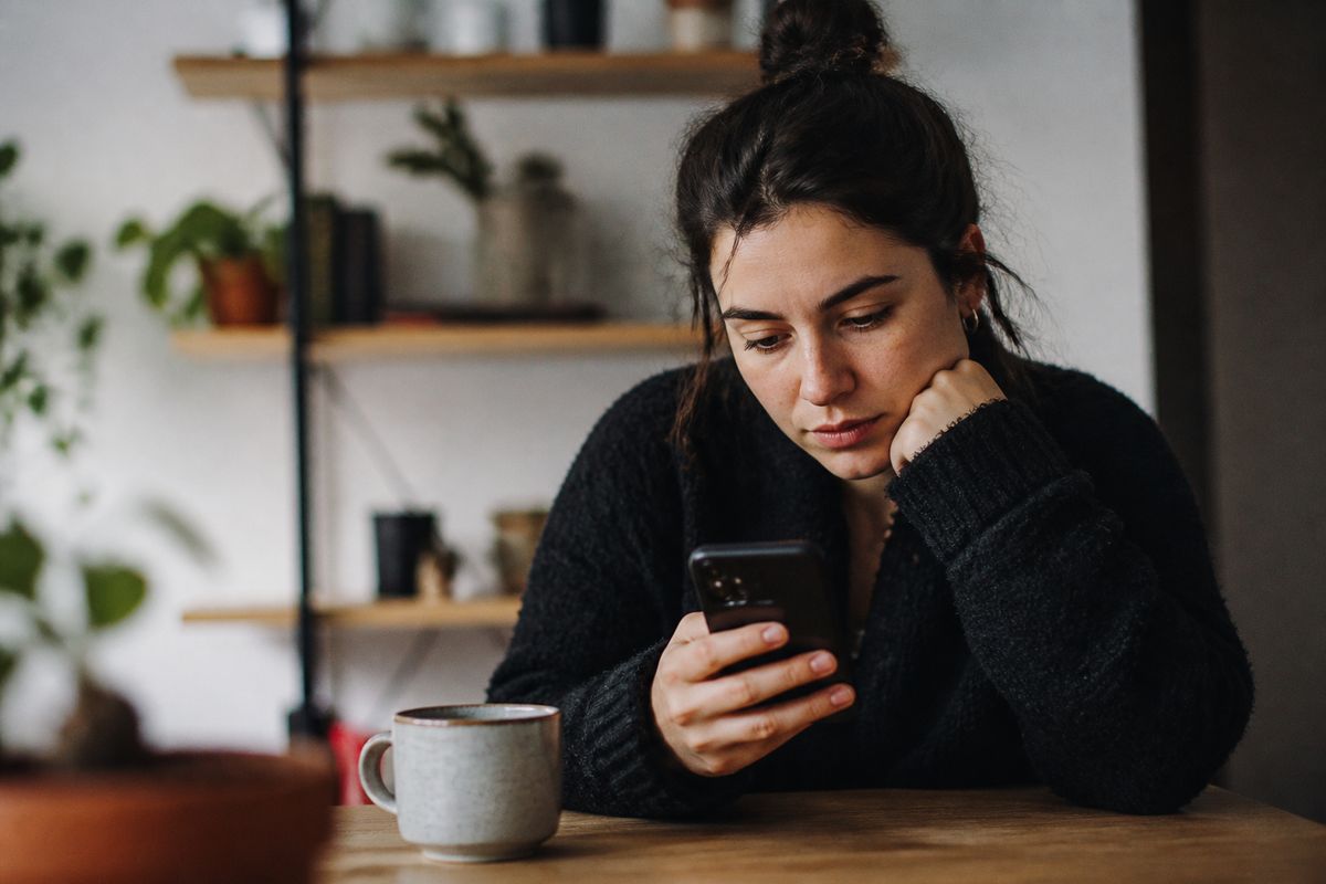 A young woman comparing savings apps on her smartphone.