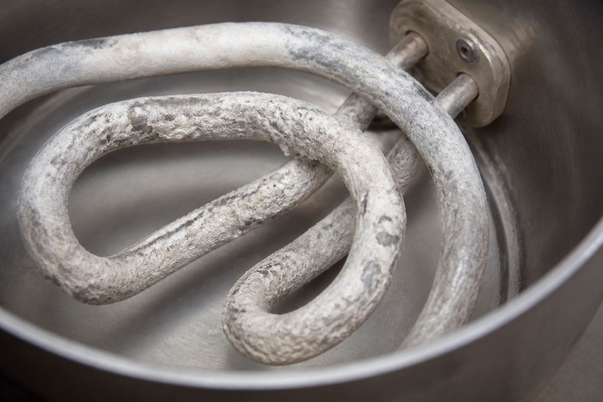 Close-up of a kettle heating element covered in limescale buildup