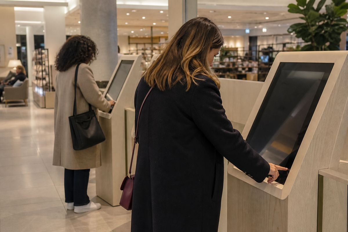 Shoppers using AI-assisted kiosks inside a John Lewis store