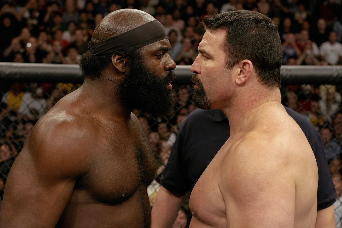 Kimbo Slice and Tank Abbott face off in a crowded MMA cage.