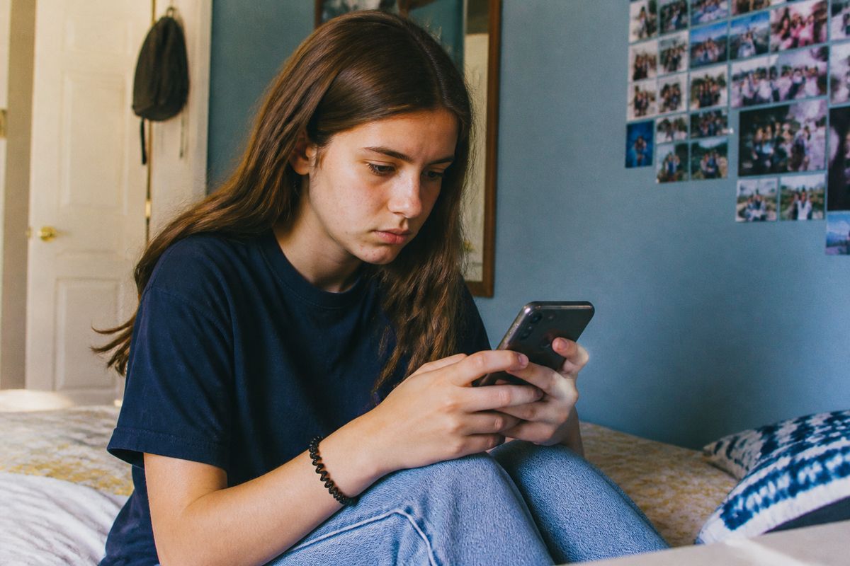 A teenager using a smartphone with parental controls visible.