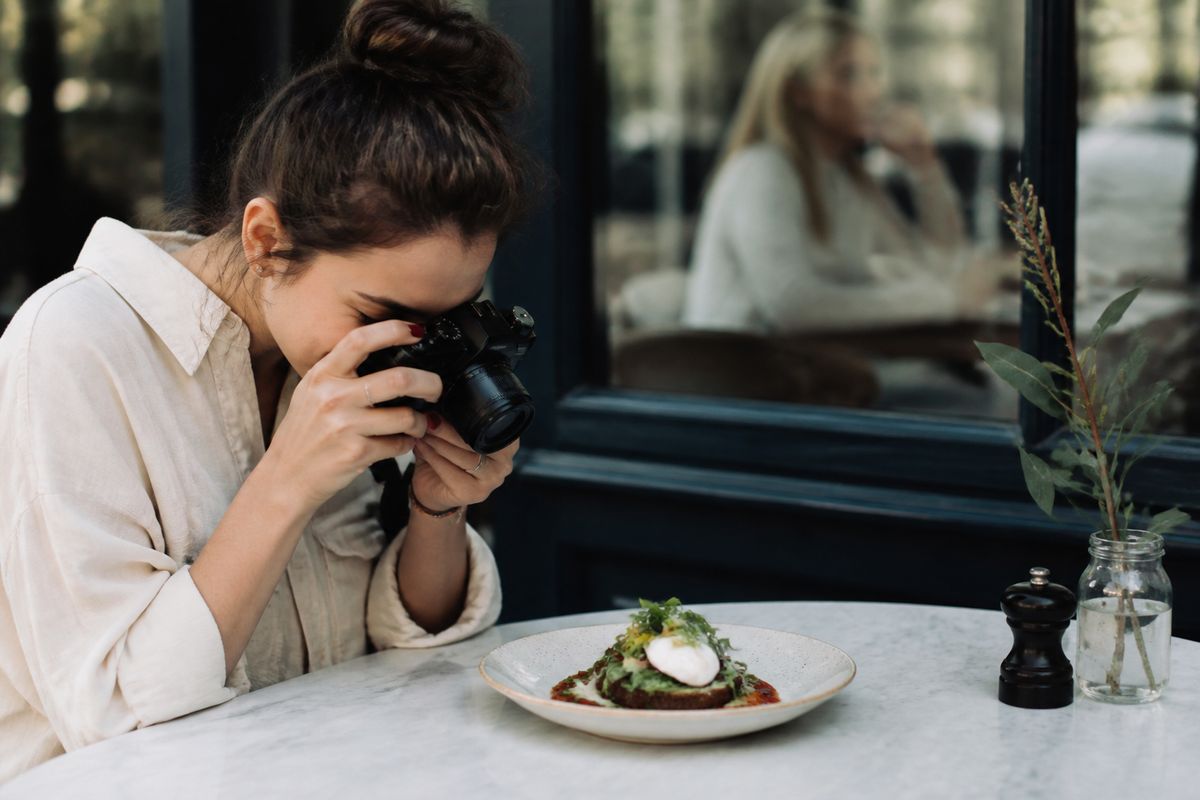 A food blogger photographing a gourmet dish in a London cafe
