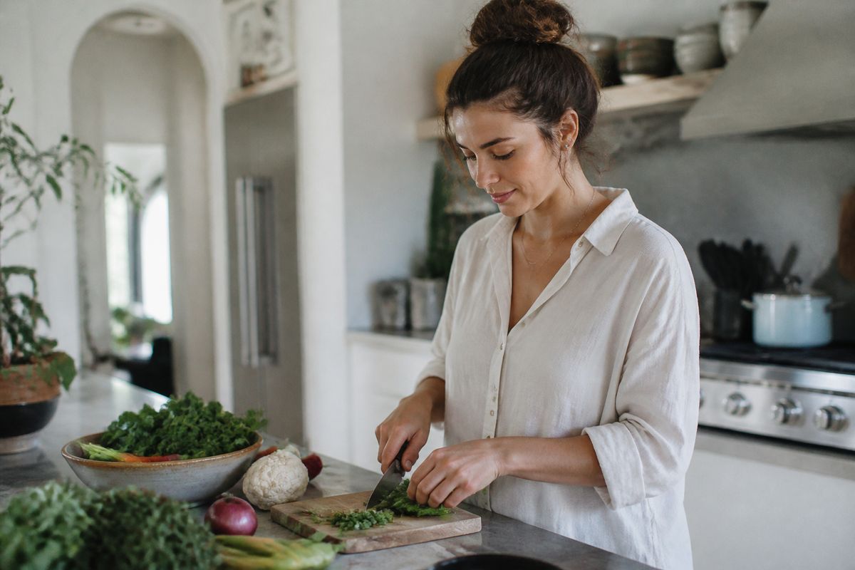 A woman cooking a healthy meal in a modern kitchen.
