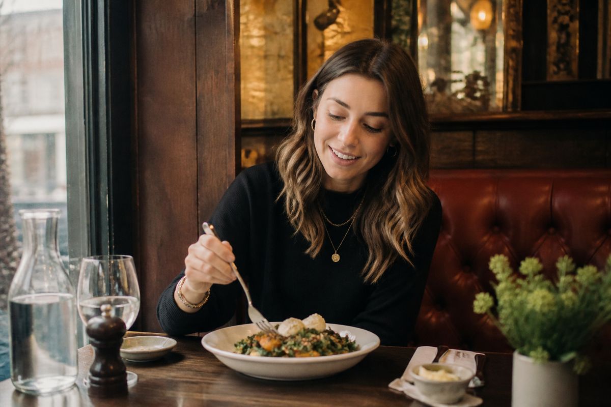 A food blogger enjoying a meal at a cozy London restaurant