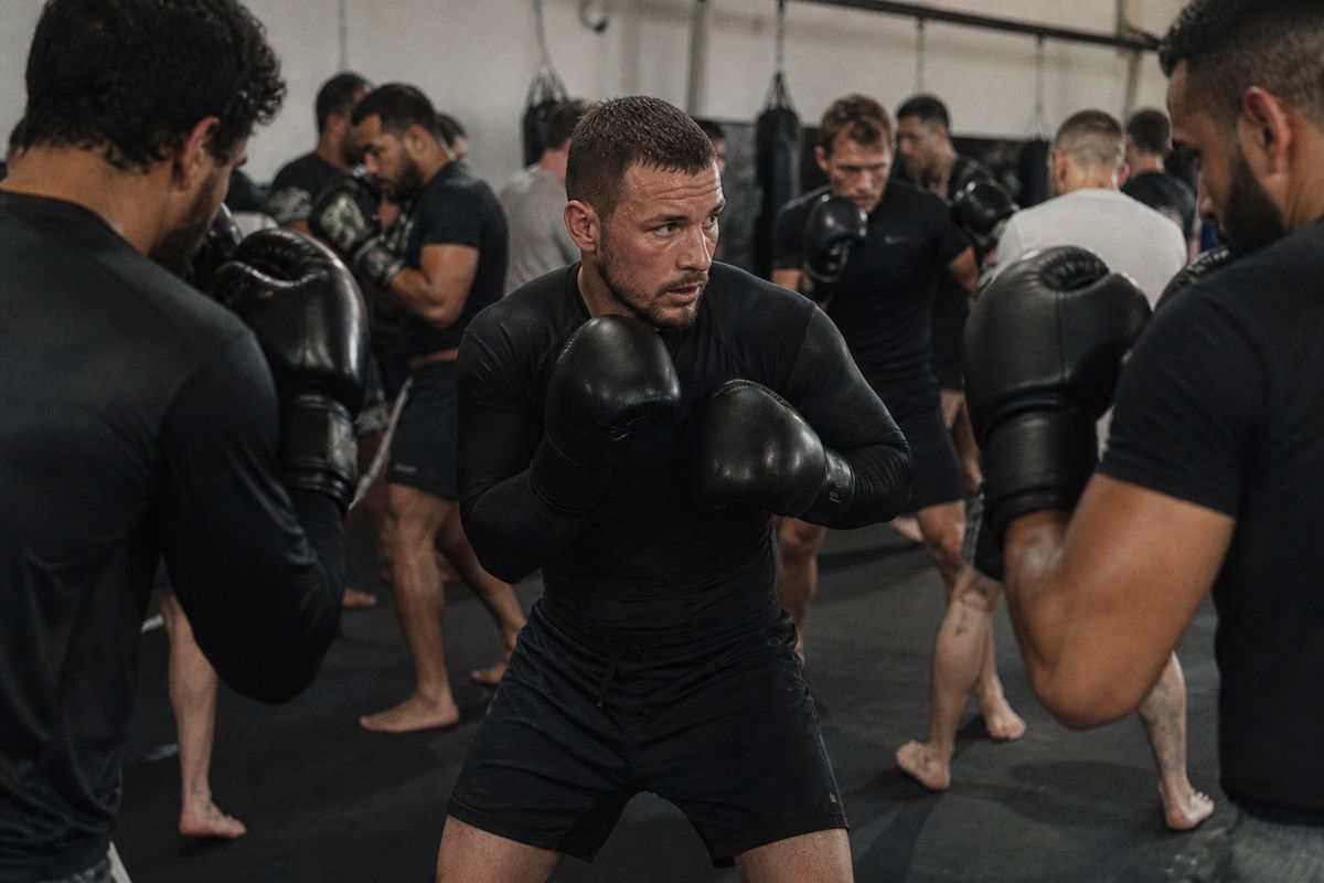 A group training in a crowded MMA gym session