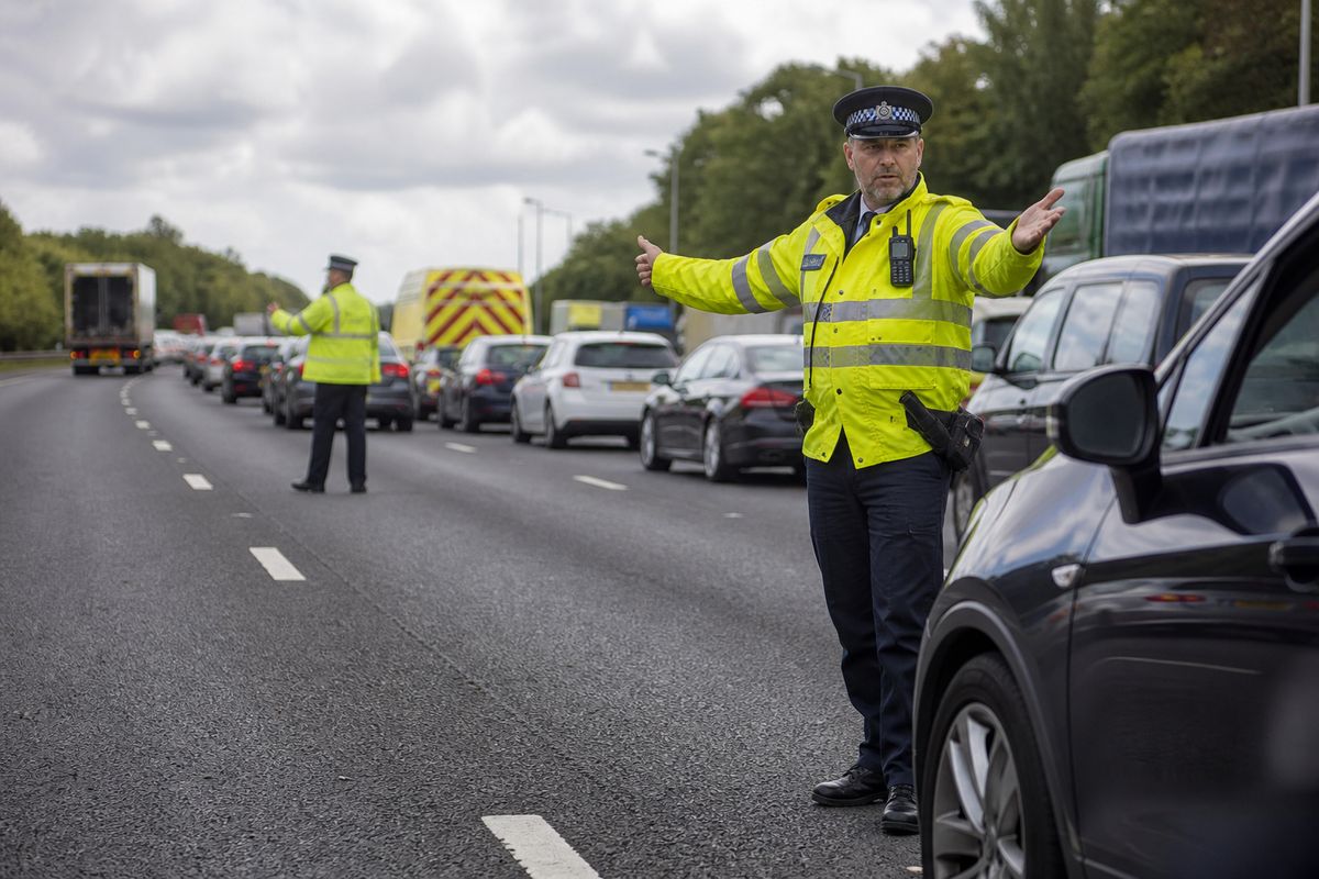Traffic officers directing vehicles on a congested M25 motorway
