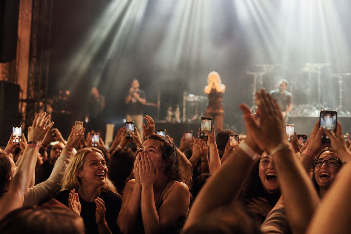 Fans cheering as a concert surprise announcement unfolds on stage