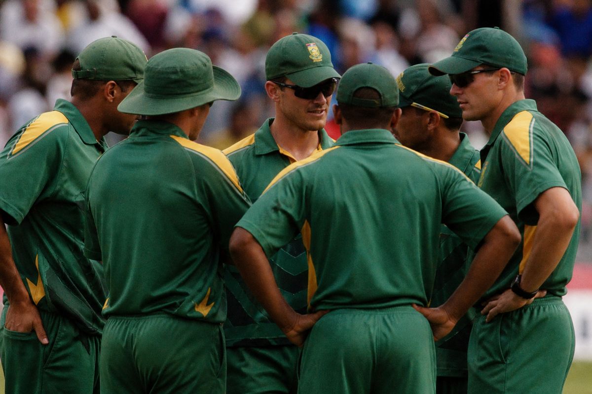 South African cricket team strategizing on the field during a match.