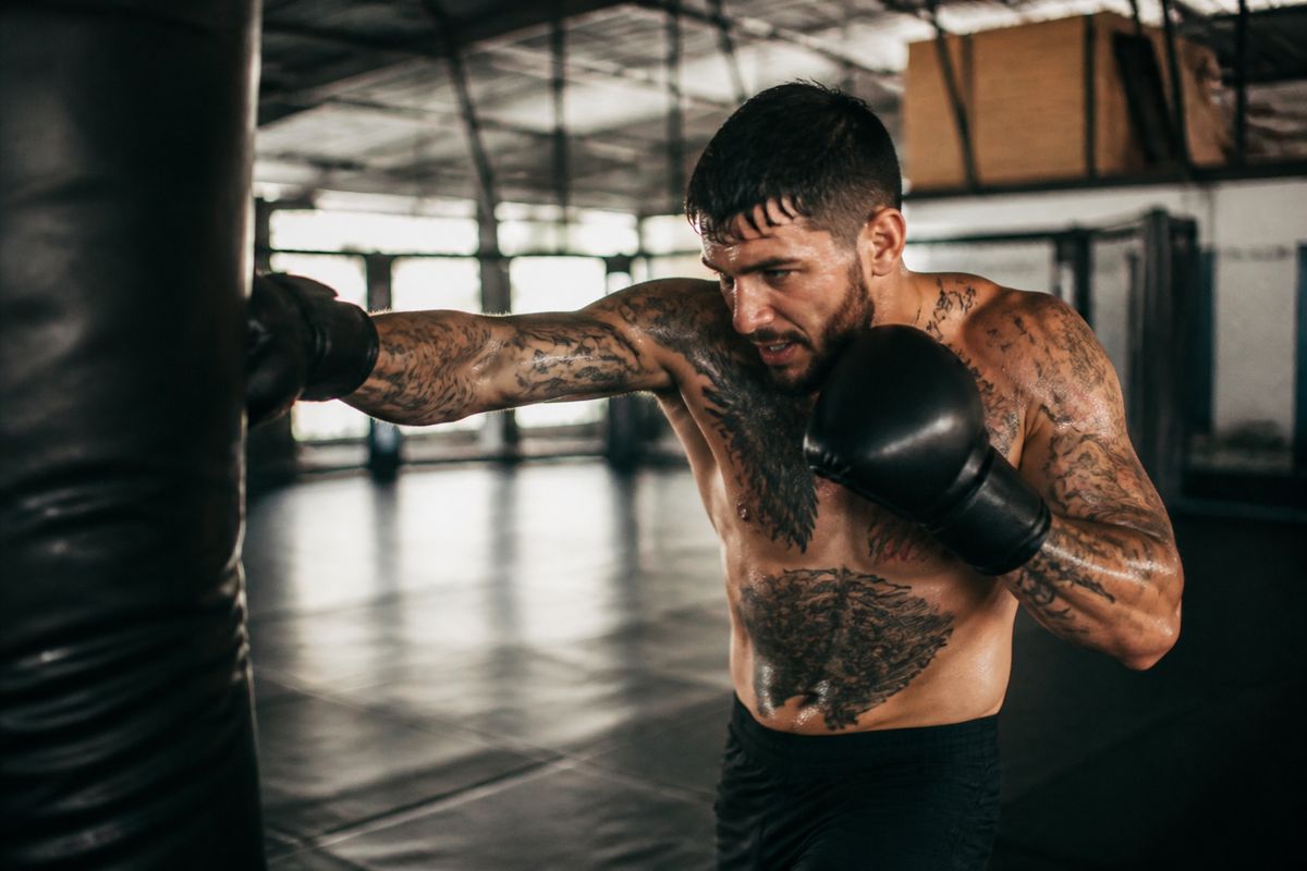 A mixed martial artist training intensely in a gym.