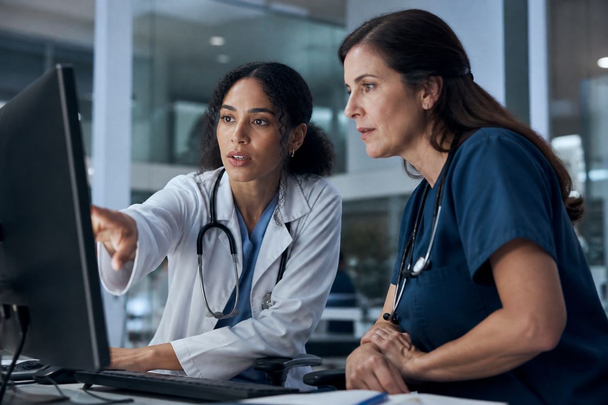 Healthcare professionals reviewing AI data on a hospital computer screen