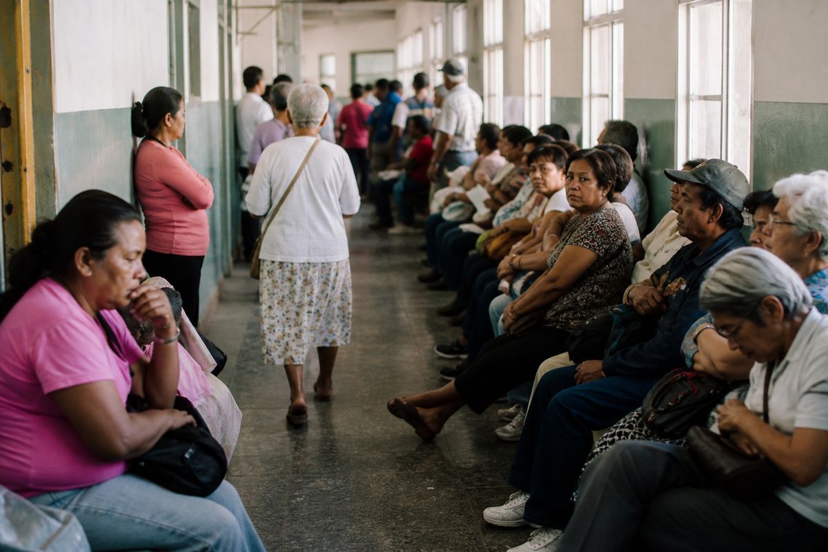 Patients waiting in a crowded hospital outpatient clinic hallway