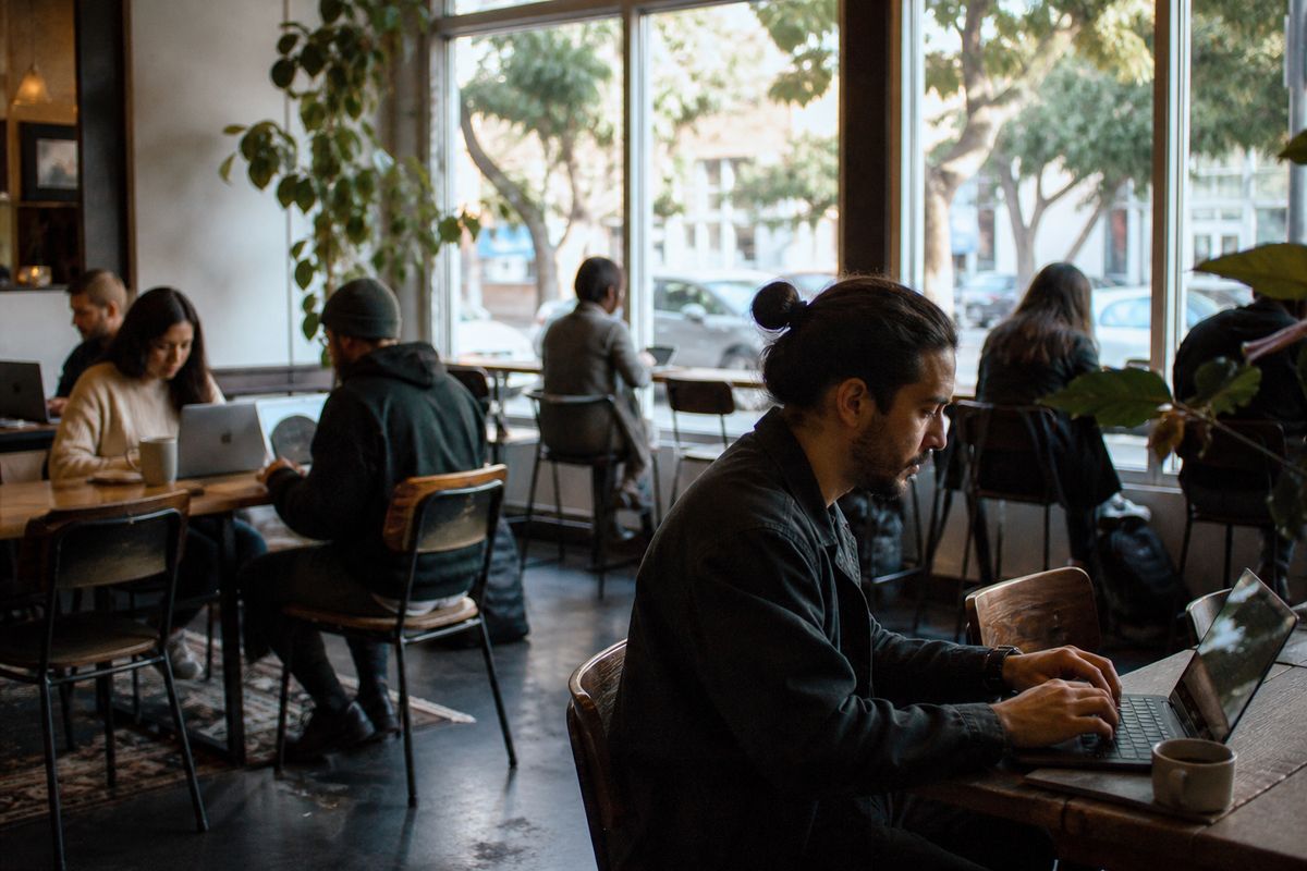 Customers working on laptops at a lively San Jose coffee shop