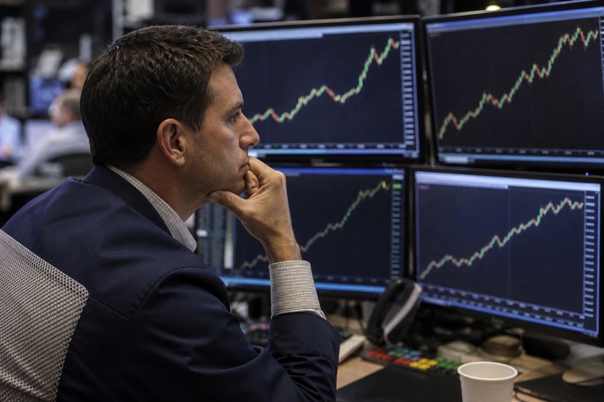 A trader watching rising bond yield numbers on multiple screens