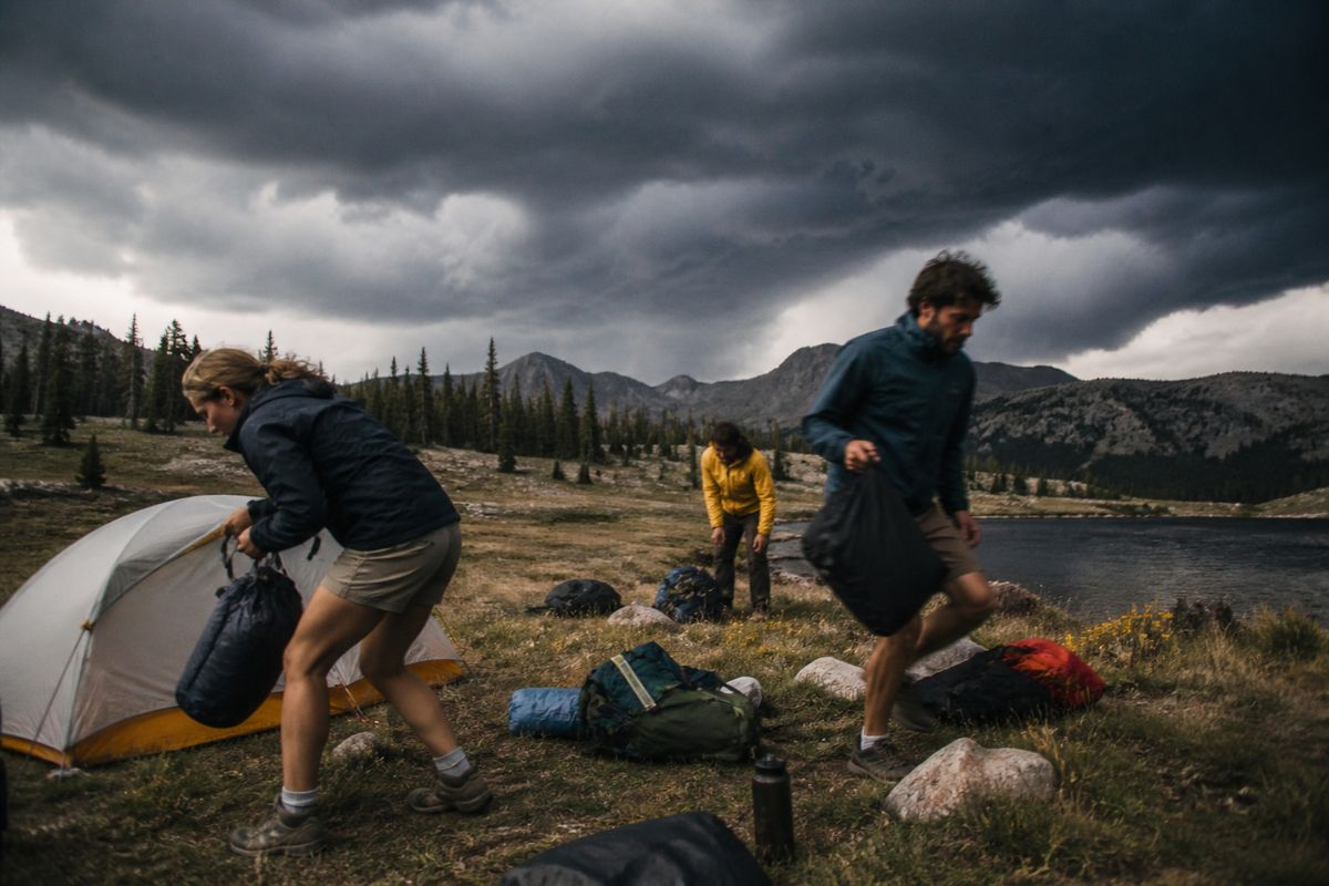 Campers hurriedly packing gear as dark storm clouds gather