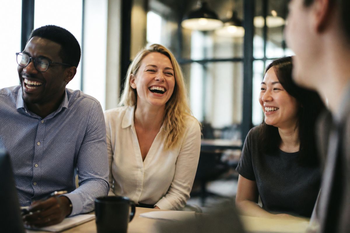 Colleagues laughing together during a Slack icebreaker session