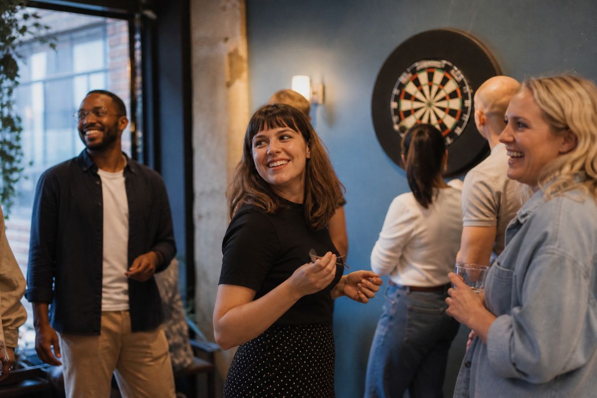 Colleagues enjoying social darts at a lively London venue