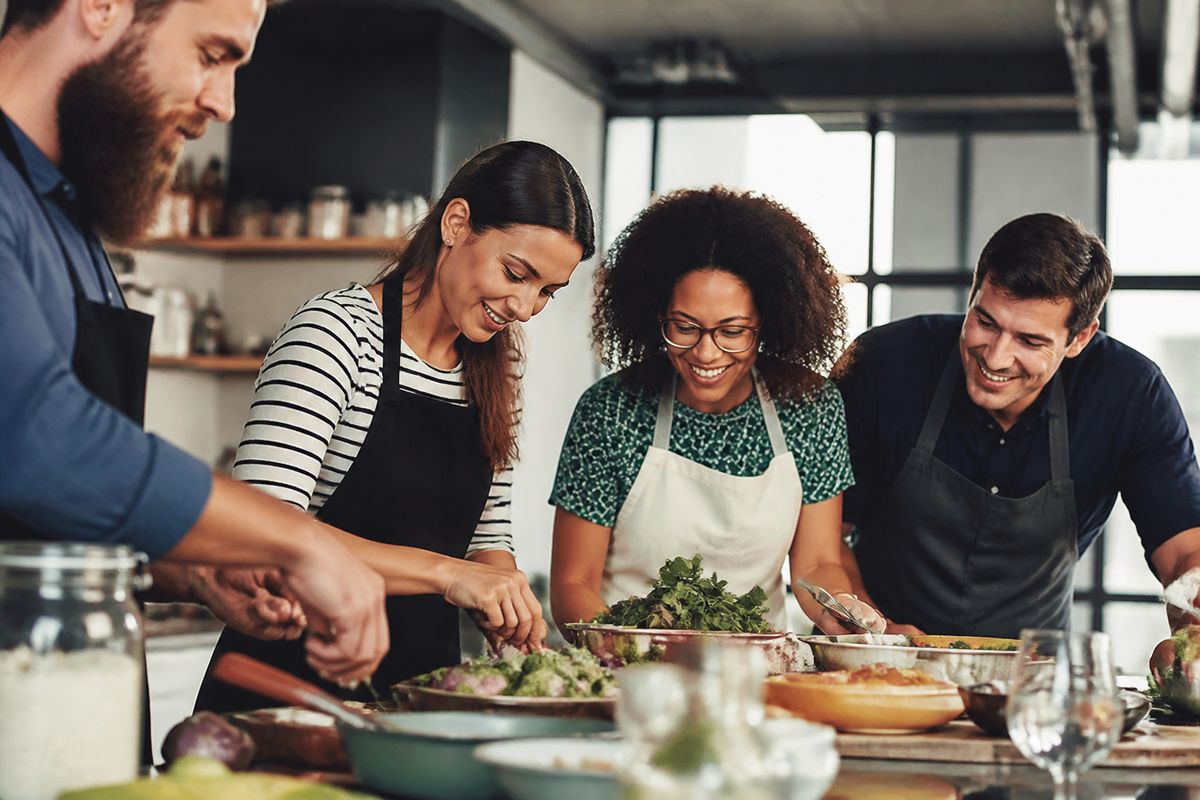 A group collaborating on a corporate cooking challenge indoors