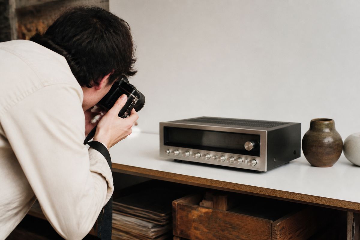 A seller photographing vintage electronics for online listing