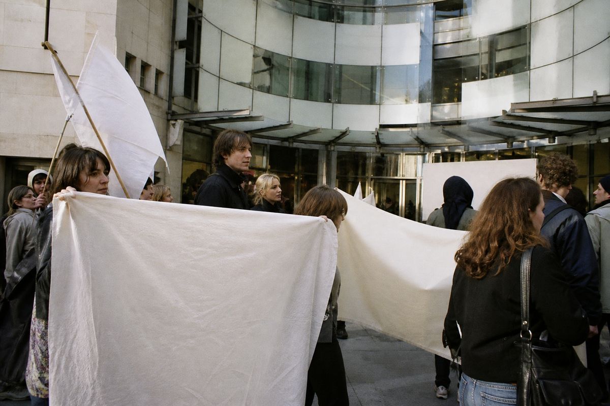 Protesters holding banners outside a broadcasting studio entrance