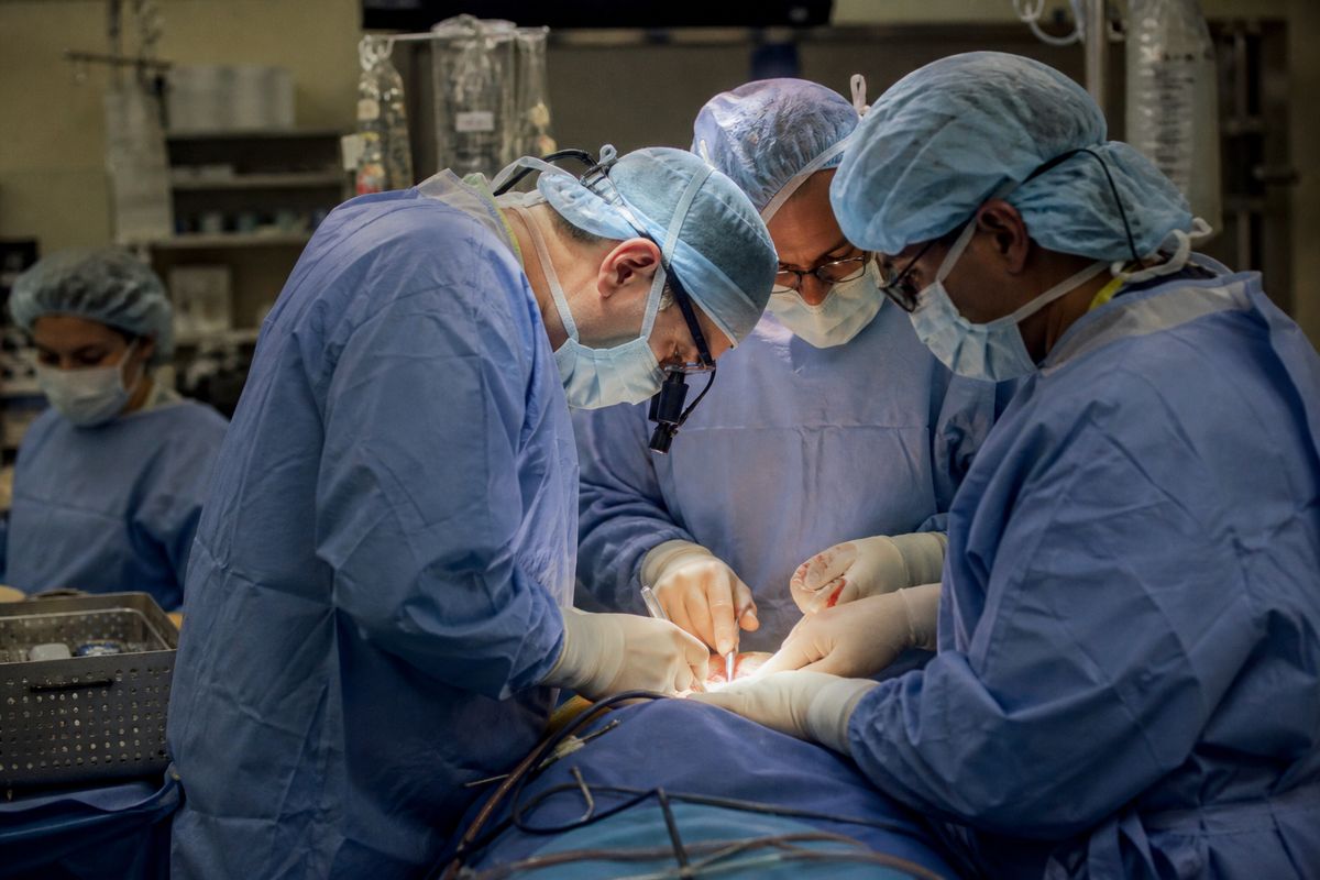Surgeons operating in a busy hospital theatre room